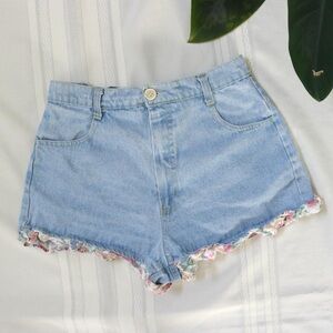 Light wash high waisted denim shorts with ruffle trim